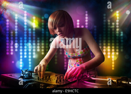 Dj girl playing songs in a disco with light show Stock Photo