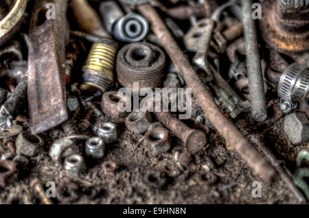 Various old and rusty nuts, bolts and tools on a work bench. Stock Photo