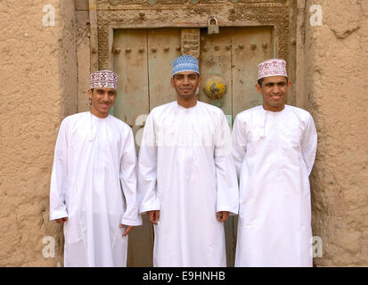 Three young Omani men in traditional dress at the ruins of Birkat Al Mouz in the Nizwa area of the Sultanate of Oman. Stock Photo