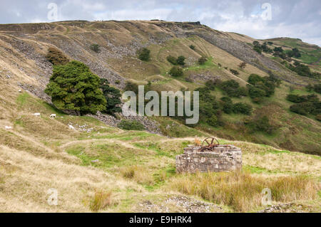 Cracken edge quarries near Chinley in Derbyshire. Winding gear below the edge. Sycamore and Hawthorn trees on the slopes. Stock Photo