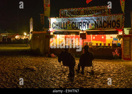 Pilton, UK, 29/06/2014 : Atmosphere at Glastonbury Festival. Sitting in deckchairs late at night near fast food outlets. Picture by Julie Edwards Stock Photo