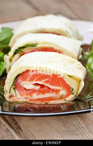 Salmon lavash rolls with cheese and herbs on glass plate, close up view Stock Photo