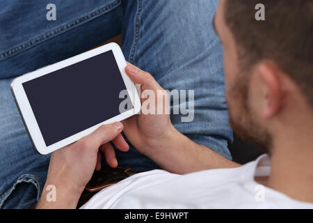 Young man using internet and looking at his tablet computer Stock Photo