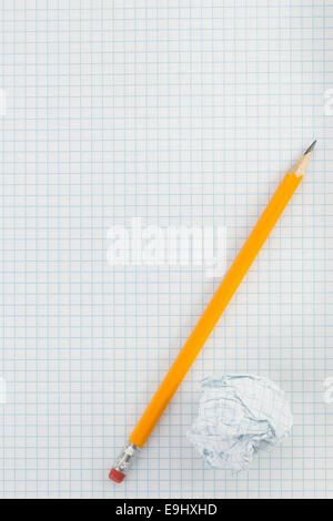 pencil and crumpled paper ball on checked background Stock Photo