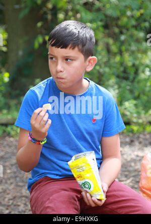 Boy eating a packet of crisps Stock Photo