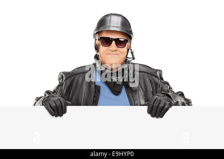 Mature biker standing behind a blank billboard isolated on white background Stock Photo
