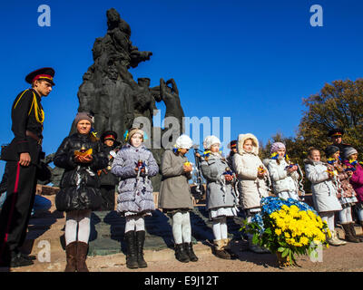 Kiev, Ukraine. 28th October, 2014. Schoolgirls lay the lamps to the monument.  Kiev cadets and schoolchildren at Babi Yar, held a rally on the 70th anniversary of Ukraine's liberation. Babii Yar tragedy known worldwide. During the Second World War, the Nazis executed here 100 thousand inhabitants of Kiev, mainly Jews. Celebration of Ukraine's liberation from the Nazis passed under the Russian occupation of the Crimea and Eastern Ukraine. Credit:  Igor Golovnov/Alamy Live News Stock Photo