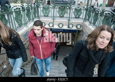 tourists and commuters exit a paris metro train station in winter with big coats on due to the cold Stock Photo