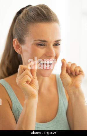 Portrait of young woman using dental floss Stock Photo