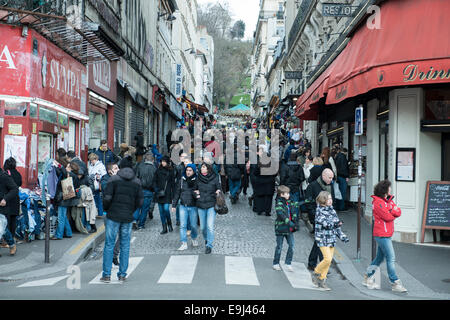 a crowd of people walking on a pedestrianised street going up hill in paris Stock Photo