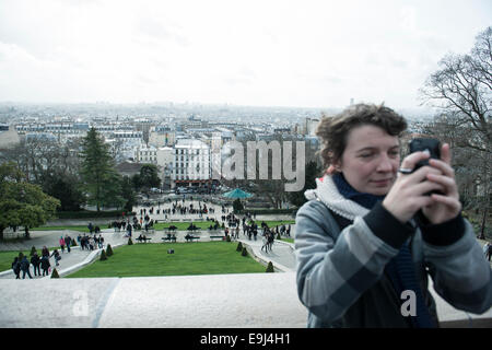 a real person / tourist taking a photo at the sacre coeur in paris at a well known tourist destination Stock Photo