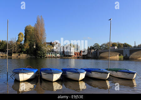 River Thames, SW London, UK. 28th October 2014. A beautiful and warm autumn morning on the River Thames at Hampton Court. Rowing boats are moored on the river bank and reflected in the calm waters. Credit:  Julia Gavin UK/Alamy Live News Stock Photo