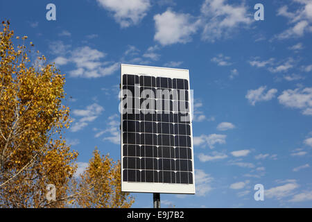 medium sized solar panel against blue cloudy sky on sunny day Stock Photo