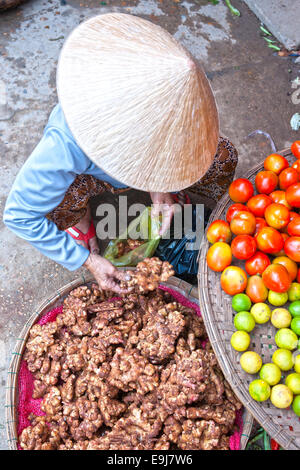 Vietnamese woman selling ginger in a market, Ho chi minh city, Vietnam. Stock Photo