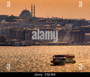 Istanbul, Turkey. 2nd Oct, 2004. In the glow of sunset a ferry crosses the Bosporus. On the skyline are the dome and minarets of the Yeni Camii, or New Mosque. © Arnold Drapkin/ZUMA Wire/Alamy Live News Stock Photo