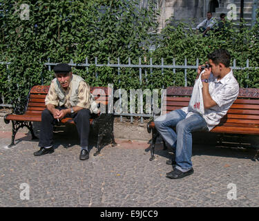 Istanbul, Turkey. 2nd Oct, 2004. A young male tourist photographs an elderly local man sitting on a bench, smoking, in Istanbul, Turkey. © Arnold Drapkin/ZUMA Wire/Alamy Live News Stock Photo