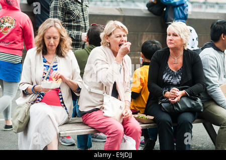 Women eating at 'Viva Victoria' Multicultural Festival, Yarra River Bank, Melbourne, Victoria, Australia Stock Photo