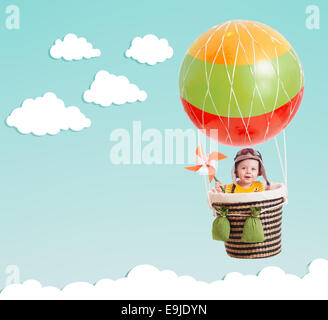 cute kid on hot air balloon in the blue sky Stock Photo