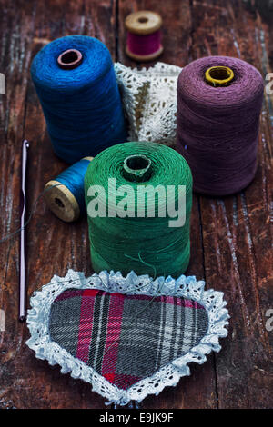 set of threads of different types,colors and lengths on wooden background Stock Photo