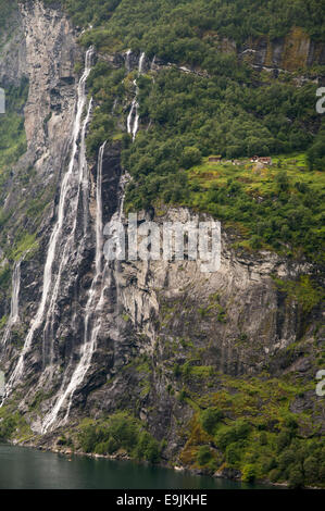 Knivsflå farm sitting about 250 meters above the fjord next to the Seven Sisters waterfall in Geiranger fjord, Norway. Stock Photo