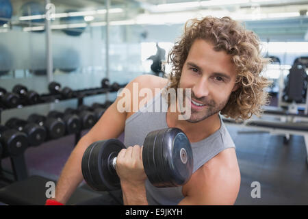 Young man exercising with dumbbell in gym Stock Photo