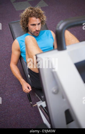 Young handsome man doing leg presses in gym Stock Photo