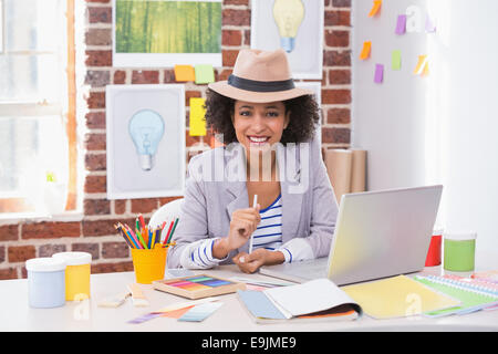 Smiling female interior designer at desk Stock Photo