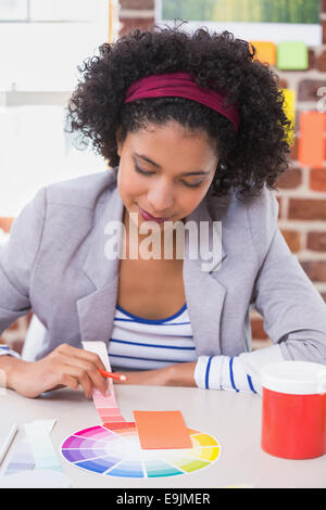 Female designer with color samples at desk Stock Photo