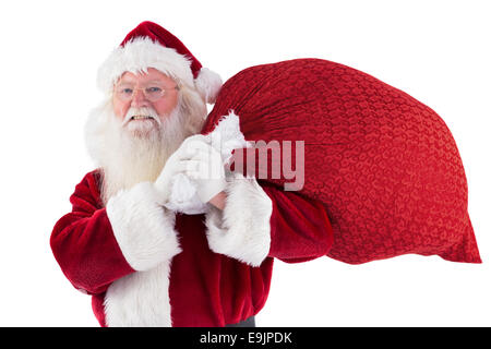 Santa carries his red bag and smiles against red background Stock Photo ...