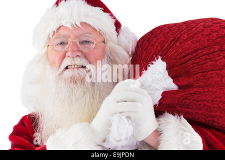 Santa carries his red bag and smiles Stock Photo - Alamy