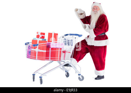 Santa pushes a shopping cart while reading Stock Photo