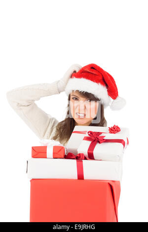 Attractive santa woman scratching head and holding gifts Stock Photo