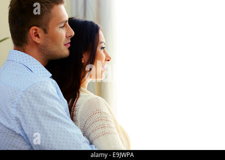 Side view portrait of a couple looking at window Stock Photo