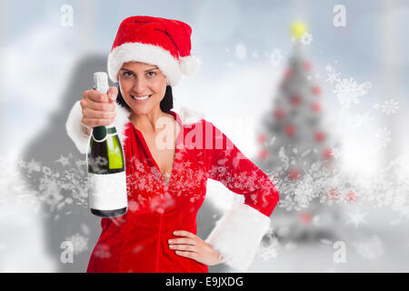 Composite image of woman holding a champagne bottle Stock Photo