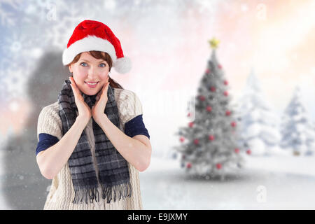 Composite image of smiling woman wearing santa hat Stock Photo