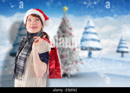 Composite image of smiling woman wearing santa hat Stock Photo