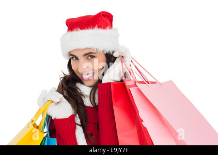 Festive brunette in winter wear holding shopping bags Stock Photo