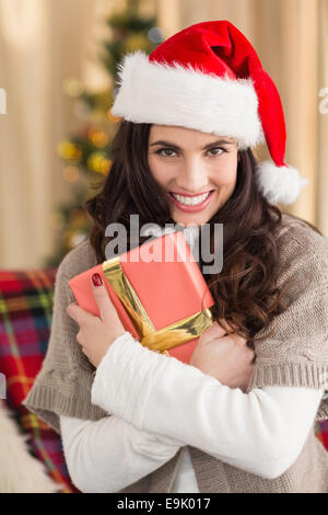 Festive brunette pressing gift at christmas Stock Photo