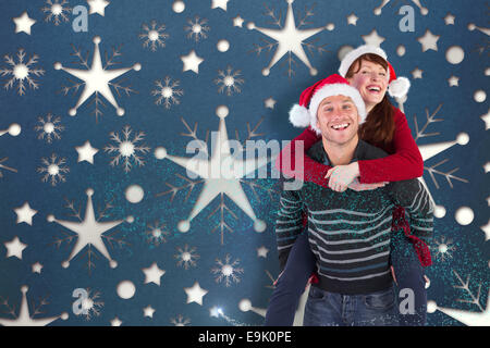 Composite image of man giving woman piggy back Stock Photo