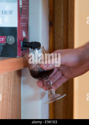 Pouring a glass of red wine from a box. Stock Photo