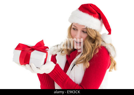 Surprised blonde in santa hat holding gift Stock Photo