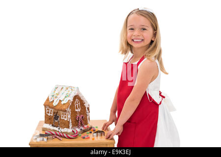 Festive little girl making gingerbread house Stock Photo