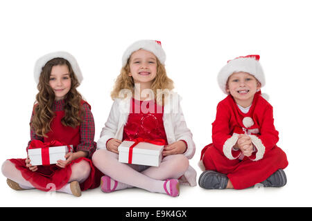 Festive little siblings smiling at camera holding gifts Stock Photo