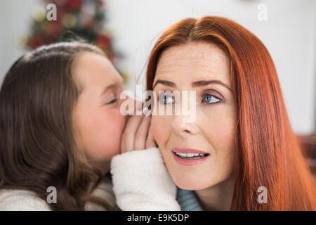 Daughter telling her mother a christmas secret Stock Photo