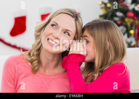 Daughter telling her mother a christmas secret Stock Photo