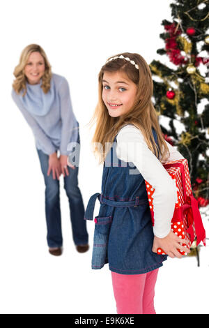 Little girl hiding christmas gift from mother Stock Photo
