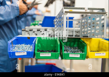 Variety of screws in tray with engineers working at electronics industry Stock Photo