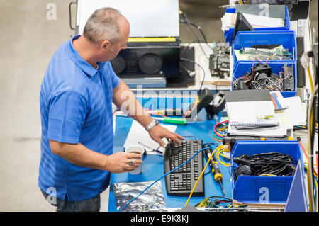 High angle view of mature male engineer working at desk in computer manufacturing industry Stock Photo