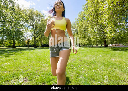 Young fit woman jogging at park Stock Photo