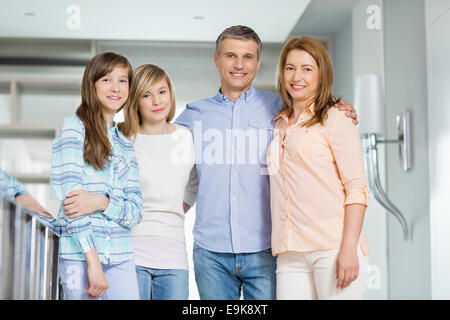 Portrait of happy parents with daughters standing together at home Stock Photo